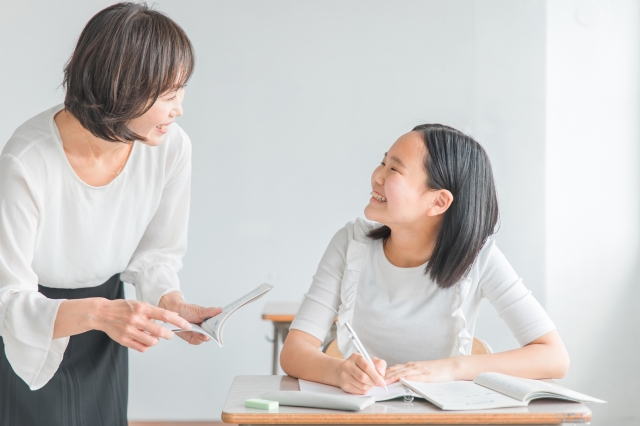 先生が優しく子どもに話しかけている。